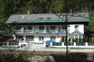 ein großes weißes Haus mit grünem Dach in der Unterkunft Alpenpension in Altaussee