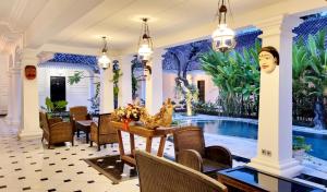 a dining room with a table and a swimming pool at Omatha Village in Denpasar