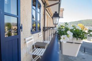 een veranda met een blauwe deur en een bank en bloemen bij Mar De Muros in Muros
