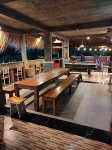 a large dining room with tables and a pool table at Karma Backpacker in Uluwatu
