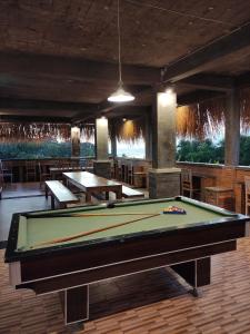 a pool table in a room with tables and chairs at Karma Backpacker in Uluwatu