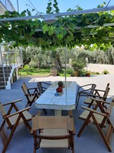a table and chairs under an umbrella on a patio at Sevastiani’s Apartments in Skala Kallirachis