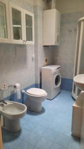 ein Badezimmer mit einem WC und einer Waschmaschine in der Unterkunft Appartamento Nuccia - Box Auto Gratuito e Biancheria Inclusa in Pietra Ligure
