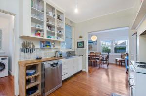 a kitchen with white cabinets and a dining room at Deckhouse in Port Fairy