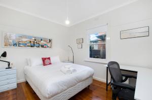 a bedroom with a bed and a desk and a chair at Deckhouse in Port Fairy