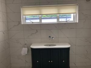 a bathroom with a sink and a window at Highgrange Apartments in Dundalk +44 photos