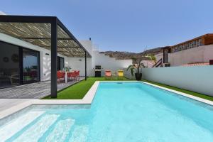 a swimming pool in the backyard of a house at Tauro Serenity by VillaGranCanaria in La Playa de Tauro