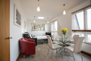 a dining room and living room with a table and chairs at Parnell Boulevard Apartments in Dublin +36 photos