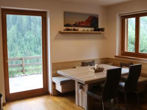 comedor con mesa, sillas y ventana en Italian Apartment with Hot Tub en Arabba
