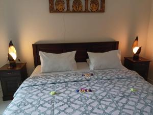 een bed met 2 kussens en 2 lampen op tafels bij Rumah Askara in Lovina