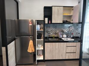 a small kitchen with a stainless steel refrigerator at AMNI Homestay Vista Bangi Muslim Preferred (Pool View) in Kajang