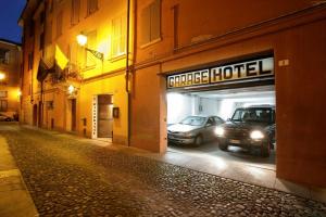 Una calle por la noche con coches aparcados en un garaje en Hotel Cervetta 5, en Módena