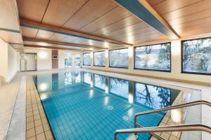 a swimming pool in a house with windows at Hotel Gasthof Stern in Nova Ponente