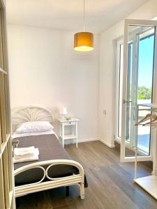 1 dormitorio con cama y ventana grande en VIlla Sunlight Sardegna, en Santa Luria