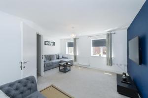 a living room with a couch and a tv at Arkwright House - Modern Townhouse close to Nottingham City Centre in Nottingham