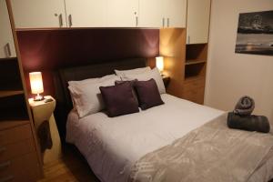 1 dormitorio con 1 cama grande y 2 almohadas en Italian Apartment with Hot Tub en Arabba