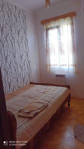 a bed in a room with a window at Hotel Kharabadze in Kutaisi