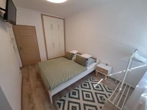 een kleine slaapkamer met een bed en een deur bij Lily Apartman Siófok in Siófok