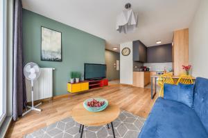 salon z niebieską kanapą i stołem w obiekcie Blue Moon with Sea View - Spectrum w Gdańsku