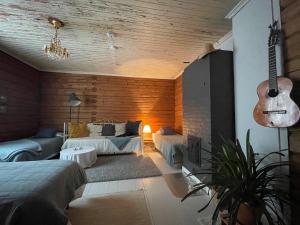 a living room with a guitar and a couch at Villa Ora’s Majatalo in Kolinkylä +10 photos