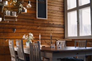 a wooden dining room with a table and chairs at Villa Ora’s Majatalo in Kolinkylä