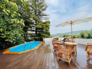 a deck with a table and chairs and an umbrella at Sra da Oliveira Solar Heritage in Leiria