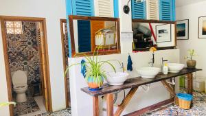 a bathroom with two sinks and two mirrors at Hotel De Condor in Con Dao