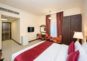 a hotel room with a large bed and a desk at City Stay Premium Hotel Apartments in Dubai