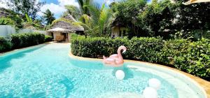 un cisne rosa en una piscina en una casa en ARYA Boutique Resort en Kiwengwa
