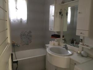 a white bathroom with a sink and a bath tub at Vintage Beach House in Alexandroupoli