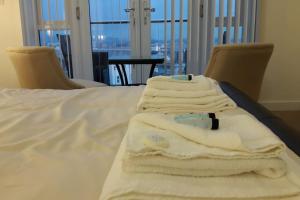 a pile of towels sitting on top of a bed at Modern Apartment with Stunning Sea View in Weston-super-Mare