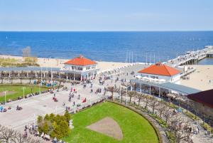 grupa ludzi chodzących po chodniku blisko oceanu w obiekcie Blue Moon with Sea View - Spectrum w Gdańsku