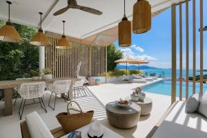 a patio with a table and chairs and a pool at BEACHSIDE VILLA - CLOUD 9 - at BAYSIDE LUXURY VILLAS Samrong Bay Beach, 3 BED 4 BATH, SALT WATER POOL, SEA and SUNSET VIEWS, only 200m walk to the Beach in Amphoe Koh Samui