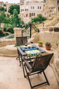 uma mesa com duas cadeiras e dois copos de vinho em Elaa Cave Hotel em Ortahisar