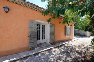 una casa de naranja con una puerta blanca y un árbol en La Petite Maison - Mas des Sous Bois en Ventabren
