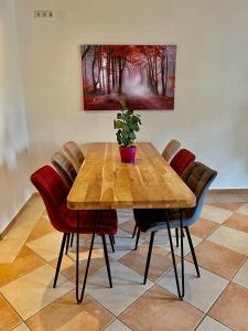 uma mesa de madeira com cadeiras e um vaso de plantas sobre ela em Ferienwohnungen Dehn em Bad Dürkheim