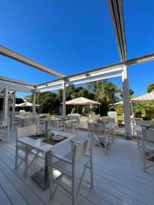 a dining area with white tables and chairs on a deck at Relais Corte Degli Aragonesi in Ischia