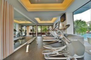 a gym with a row of treadmills at Abloom Exclusive Serviced Apartments in Bangkok