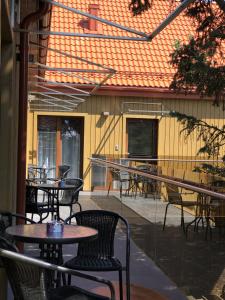 a patio with tables and chairs and a building at Vila KOPA Šventoji in Šventoji