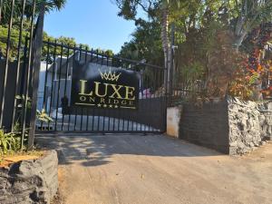 Luxe on Ridge Boutique Hotel في ديربان: بوابة حديد سوداء مفروشة مع وضع علامة عليها