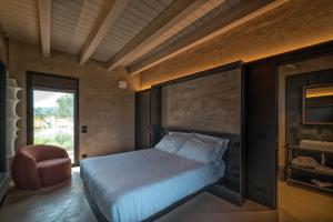 a bedroom with a bed and a chair and a window at I Vivai in Montemurlo