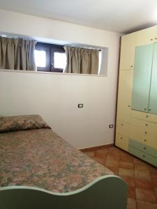 ロッサーノにあるSplendida Taverna In Villaのベッドルーム1室(ベッド1台、ドレッサー、窓付)