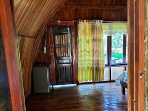 a room with wooden floors and a door and windows at FOREST BREATH ECO-LODGE in Tân Phú