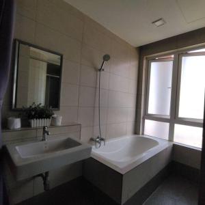 a bathroom with a tub and a sink and a window at Octagon Premium Ipoh Town Center 2BR 101 by Grab A Stay in Ipoh