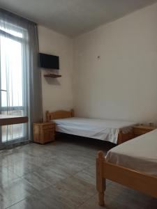 a bedroom with two beds and a television in it at Family Hotel Silitur in Ahtopol