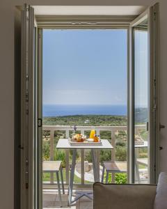 a room with a table and a view of the ocean at Salvia Areopolis All Suite Hotel in Areopoli