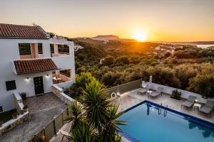 une villa avec une piscine au coucher du soleil dans l'établissement Villas Almyrida, à Almyrida