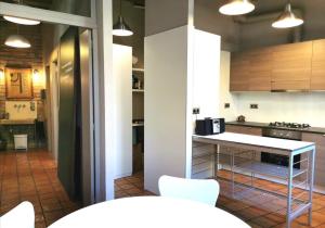 a kitchen with a table and white chairs in it at Habitació polivalent al centre de Manresa in Manresa