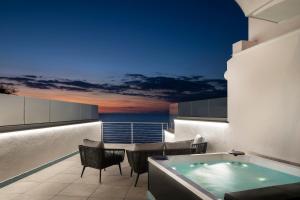 balcón con bañera de hidromasaje, mesa y sillas en Ischia Blu Resort en Ischia
