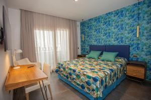 a bedroom with a bed and a table and a desk at Hotel Adiafa in Barbate